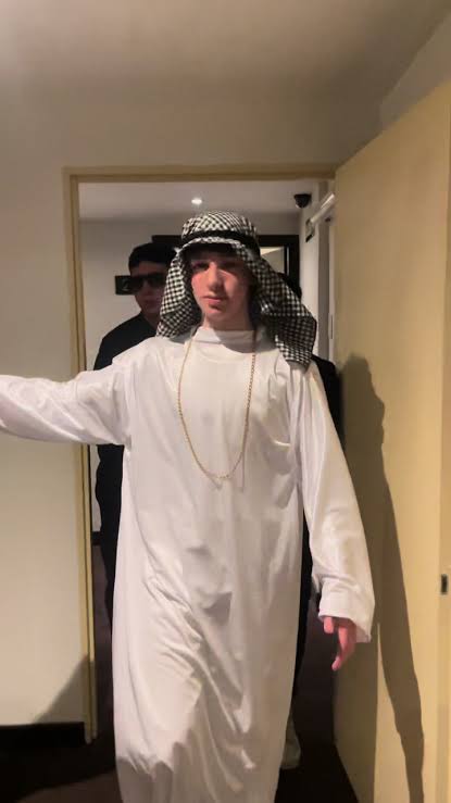 Joven con túnica árabe caminando en un pasillo